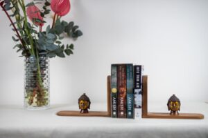 Burma teak book end with brass Buddha heads from Uttar Pradesh.