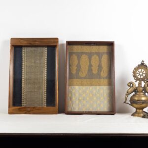 Left: Black and gold vairaoosi Kanchipuram silk inlaid in a 100 year old Burma teak frame. Right: large Burma teak tray, inlaid with a cream and gold Banaras tissue organza with traditional woven motifs.